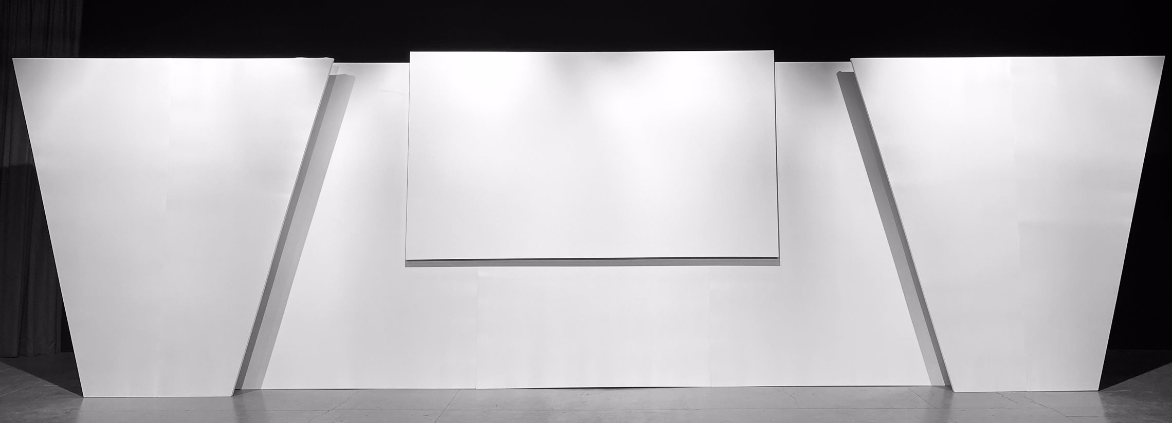 Stage Backdrops for Events - backdrop system AV drop stage backdrop for events with double depth, symmetrical sides with angled edges and a centrally positioned front projection screen.
