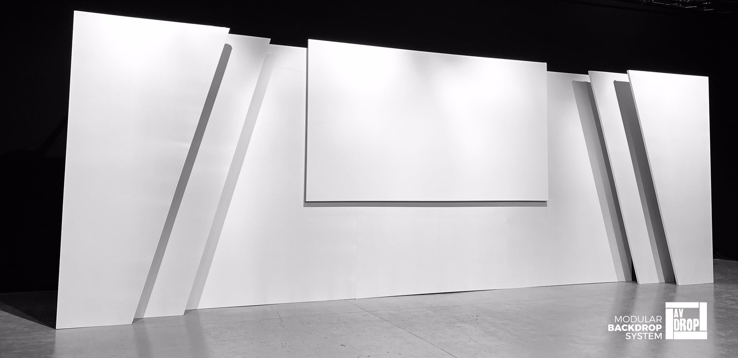 Stage backdrops for events with triple depth, symmetrical sides with two angled pieces on each side and a front projection screen in the centre.
