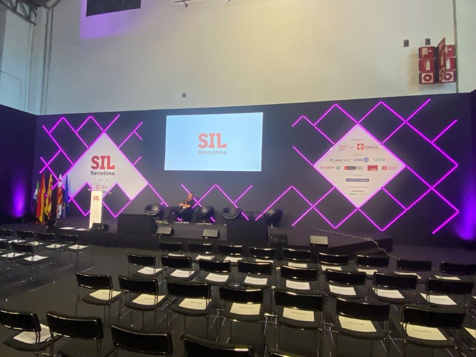 Salle de conférence avec fond de scène avec écran de projection frontale pour SIL 2022