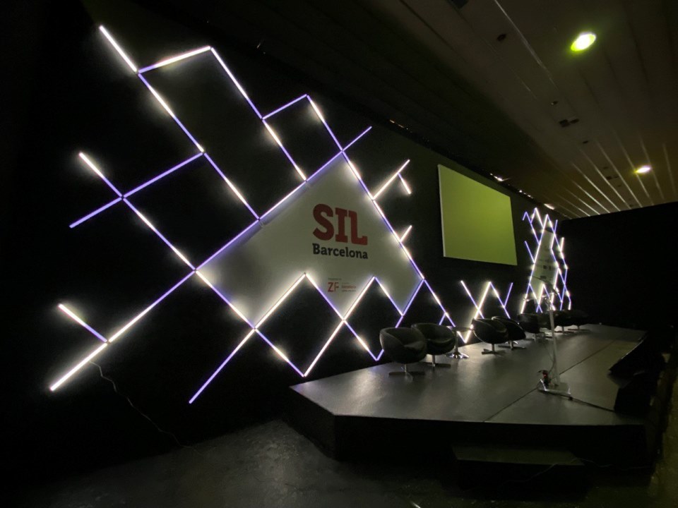 Salle de conférence avec fond de scène avec écran de projection frontale pour SIL 2022